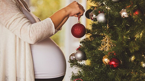 Pregnant lady decorating christmas tree