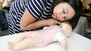 woman giving baby first aid