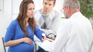 Pregnant woman with partner at doctors