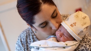 Parent kissing baby on their head after birth