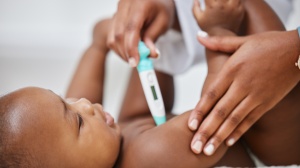 Baby having temperature taken with a thermometer