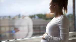 Pregnant woman looking out of the window