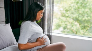 Pregnant woman or person sitting on the bed