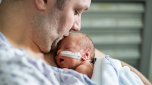 Parent holding premature baby