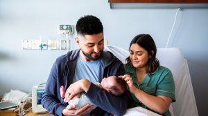 Parents holding newborn baby in hospital