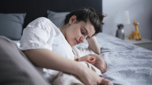 Mother or birthing person in bed with baby