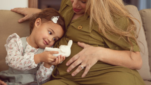 Toddler and pregnant mum sitting on a sofa