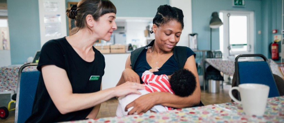 Breastfeeding counsellor supporting a mother with feeding