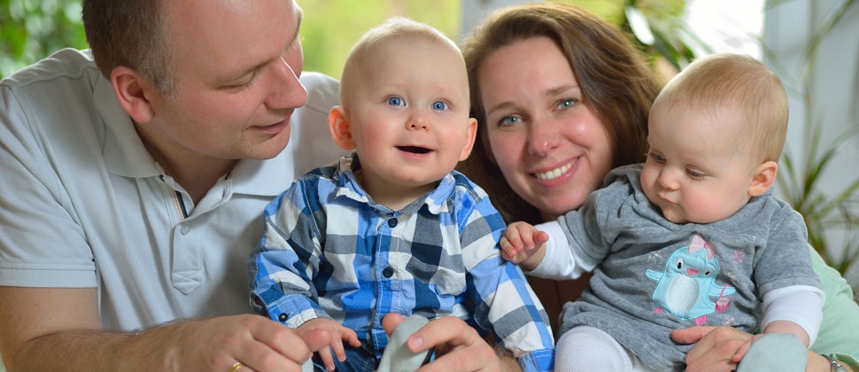 A family looking happy with twin babies