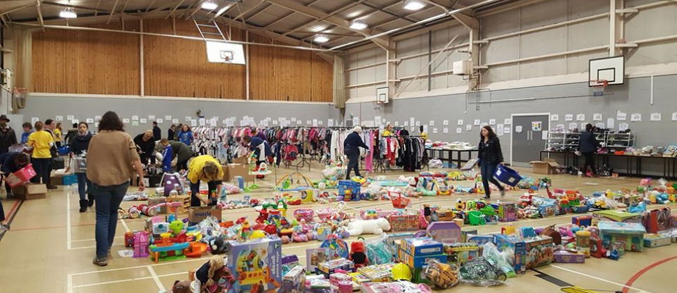 Wakefield NCT Nearly New Sale - a large sports hall with toys in the foreground and rails of clothes to the rear