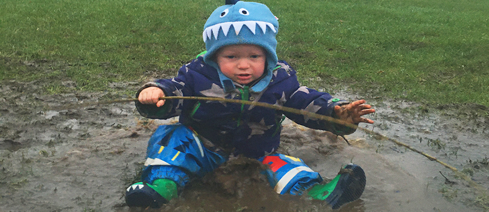 Toddler in a muddy puddle