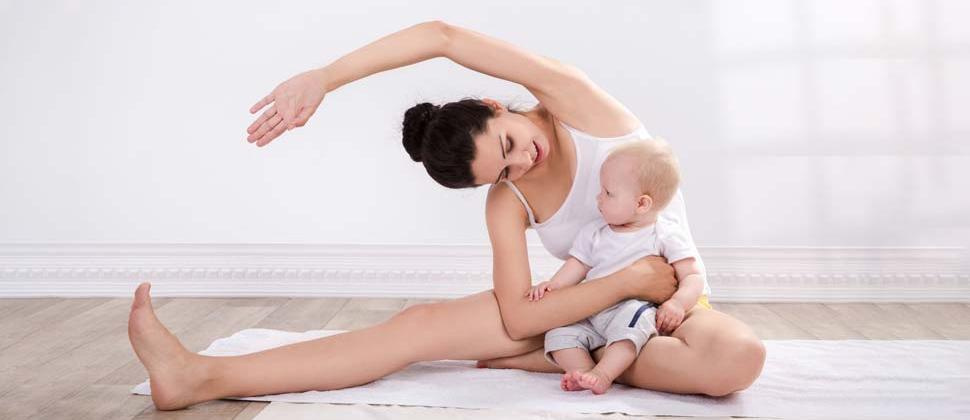 Mum holding a yoga pose with baby on lap