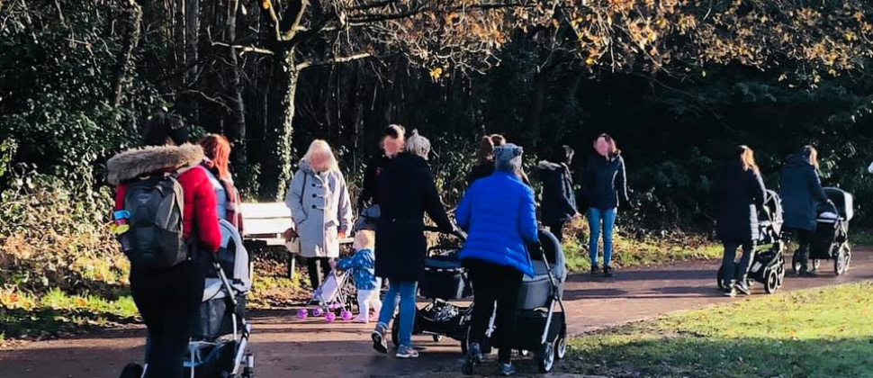 Mothers pushing their children in pushchairs on a walk