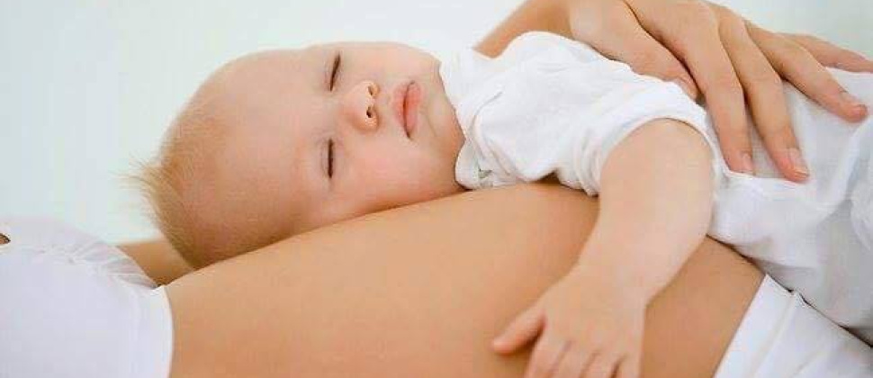 baby lying on pregnant person's tummy