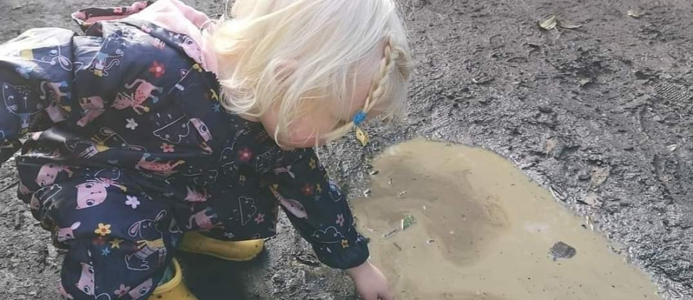 toddler playing in a puddle