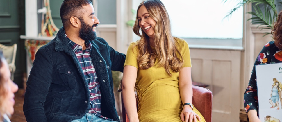 Pregnant couple laughing and chatting